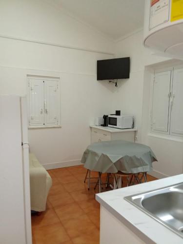 a small kitchen with a sink and a table at Casas da Saibreira - nº2 in Elvas
