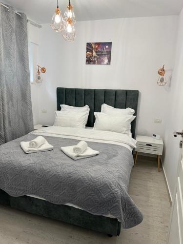 a bedroom with a large bed with two towels on it at Apartament Bonton Predeal in Predeal