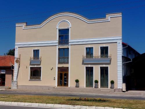 a large white building with windows and balconies at Regal Ballroom in Caransebeş