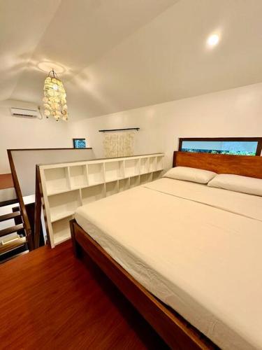 a bedroom with a large white bed in a room at Casita Ysla Tiny Home with garden kitchen wifi 2 scooters in El Nido