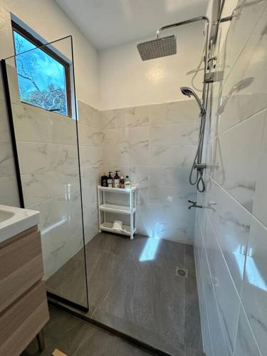 a bathroom with a shower and a sink at Casita Ysla Tiny Home with garden kitchen wifi 2 scooters in El Nido