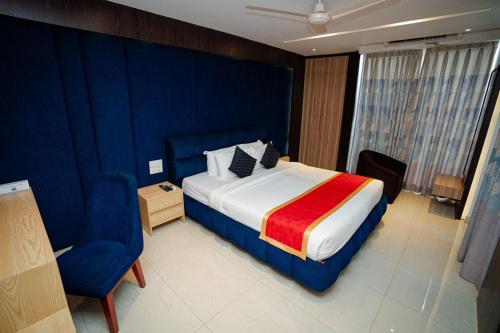 a hotel room with a bed and a chair at Royal Raj Hotel in Rājshāhi