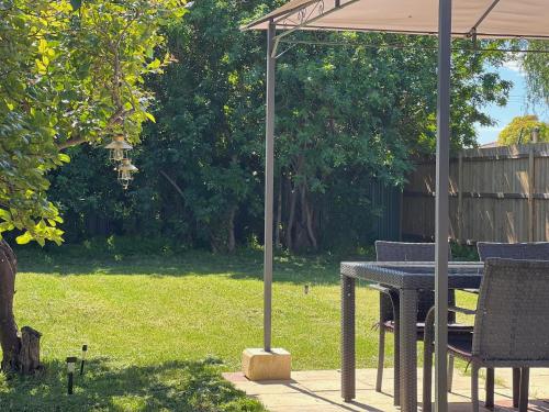 a table and chairs under an umbrella in a yard at Humble & Homely in Rockingham
