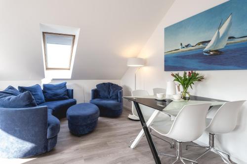 a living room with blue chairs and a table at Wasser in Ostseebad Koserow