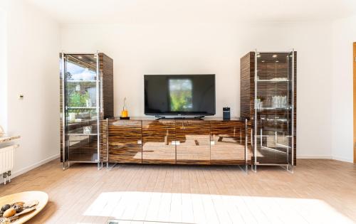 a living room with a television on a wooden entertainment center at Luft in Ostseebad Koserow