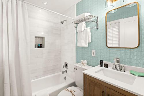 a bathroom with a tub and a sink and a toilet at Just For Fun Carriage House in Santa Rosa Beach