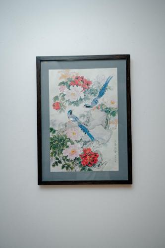 a framed picture of flowers on a wall at Royal Raj Hotel in Rājshāhi