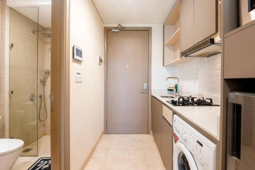 a small kitchen with a sink and a washing machine at Forest view at PIK Gold Coast in Jakarta