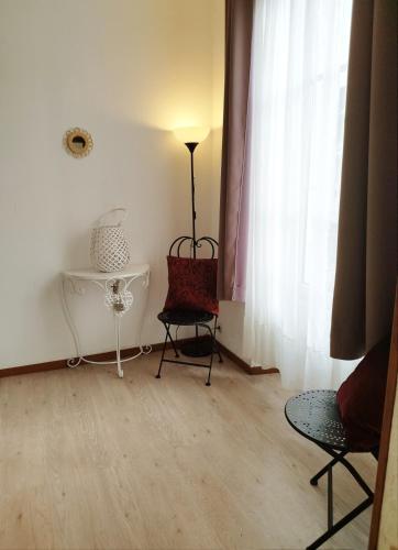 une chambre avec deux chaises, une lampe et une fenêtre dans l'établissement Cozy apartment in the heart of Chantilly!, à Chantilly