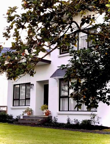 a white house with black windows and green grass at Glenview Park Cottage and Farm Stay, Yarra Glen in Yarra Glen