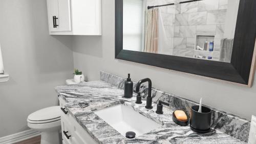 a bathroom with a sink and a toilet at Towering Pines - 3 Beds, Near Lake, Huge Backyard in Flint