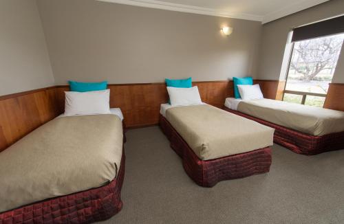 a room with three beds and a window at Berri Hotel in Berri
