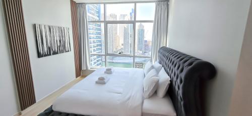 a room with a white bed and a large window at Marina View Spacious 2 BHK in Dubai