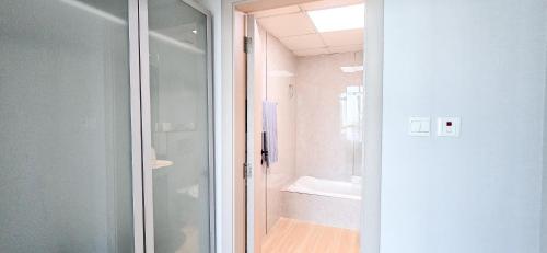 a bathroom with a shower and a glass door at Marina View Spacious 2 BHK in Dubai