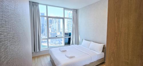 a bed in a room with a large window at Marina View Spacious 2 BHK in Dubai