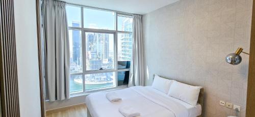 a bed in a room with a large window at Marina View Spacious 2 BHK in Dubai