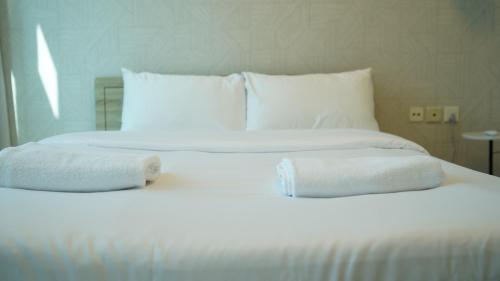 a large white bed with two towels on it at Marina View Spacious 2 BHK in Dubai