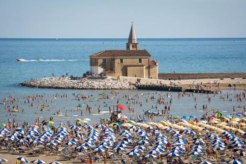 a group of people on a beach with umbrellas at Ferrari Apartments Ponente in Caorle