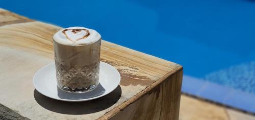 una bevanda su un piatto su un tavolo vicino a una piscina di Palm Heaven Villa a Marumbi
