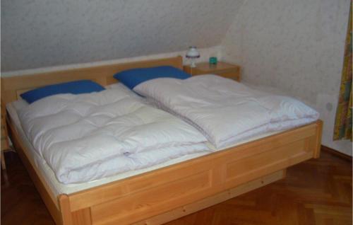 a bed with white sheets and blue pillows on it at Holiday Home Am Einsberg Q in Tellerhäuser