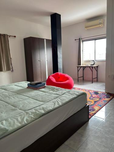 a bedroom with a large bed and a red chair at Lo Sfizio in Patong Beach