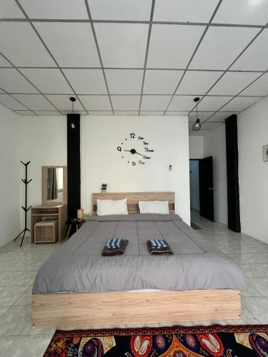 a large bed in a room with a clock on the wall at Lo Sfizio in Patong Beach