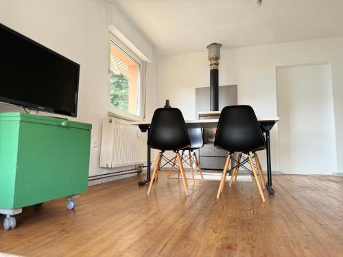 a kitchen with two chairs and a table and a television at 3 Zimmer, 100 m2, Nähe Europa-Park in Hohberg