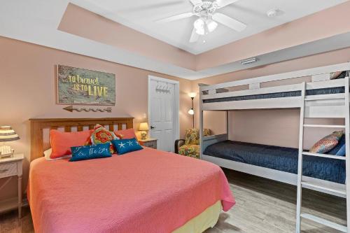 a bedroom with a bed and bunk beds at Oceanwalk 2-202 in New Smyrna Beach