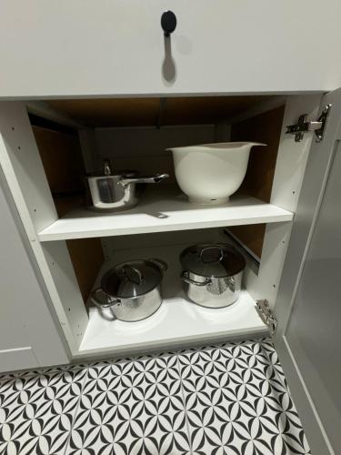 a kitchen shelf with two pots and a bowl at Apartament Green Powiśle in Kwidzyn