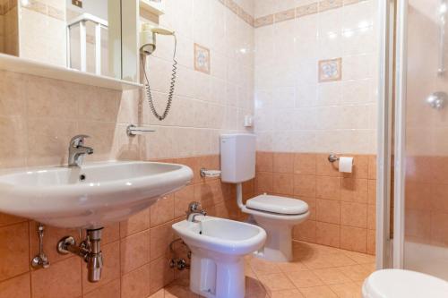 a bathroom with a sink and a toilet and a shower at Hotel il Cardo in San Vito di Cadore