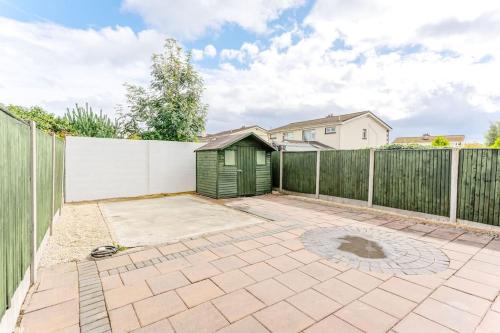 a backyard with a fence and a green shed at Celbridge House in Celbridge
