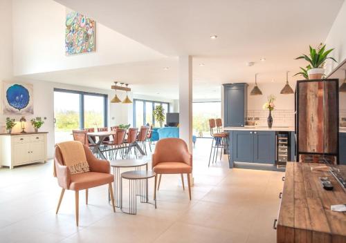 a kitchen and living room with a table and chairs at Orchard Barn - Luxury 4 BD Barn Conversion! in Fladbury