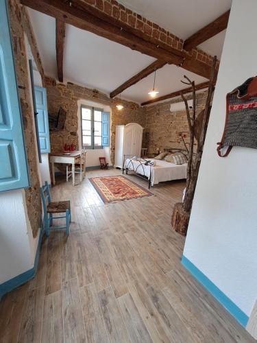 a large living room with wooden floors and a bedroom at B&B su Ponte in Orgosolo