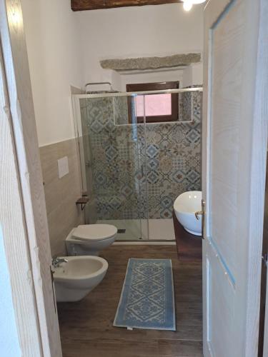 a bathroom with two toilets and a shower at B&B su Ponte in Orgosolo