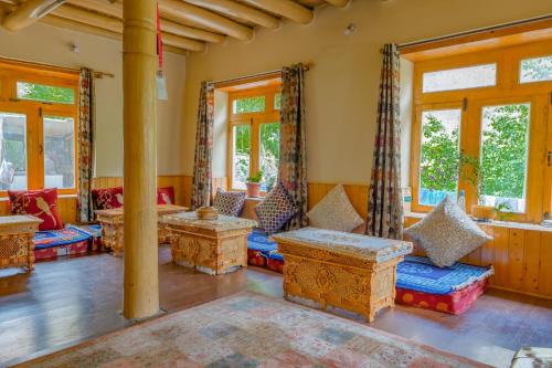 a living room with couches and windows at Domkhar Eco Homestay in Dumkhar