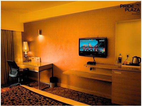 a hotel room with a flat screen tv on a wall at Pride Plaza Hotel, Ahmedabad in Ahmedabad
