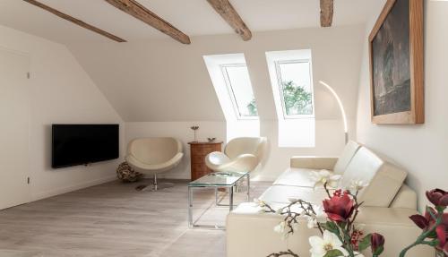 a living room with a white couch and a tv at Himmel in Zinnowitz