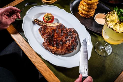 a plate of steak and a knife and a glass of wine at JW Marriott Essex House New York in New York