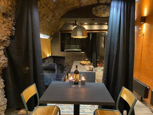 a dining room with a table with a bottle of wine at Beim Mulles - Black Smith - Vianden in Vianden