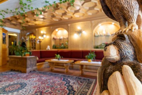 a lobby with a bear statue in the center at Hotel il Cardo in San Vito di Cadore