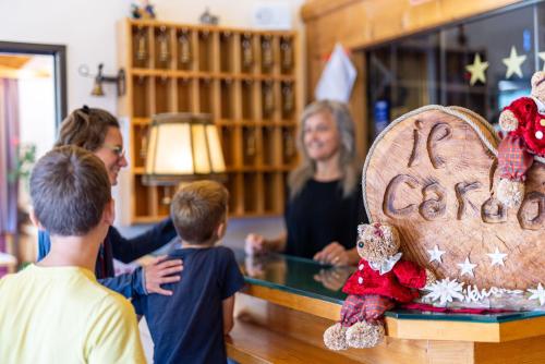 a group of children and a woman standing in a library at Hotel il Cardo in San Vito di Cadore