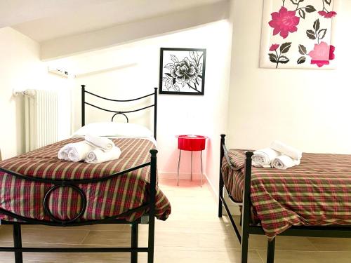 a bedroom with two beds and a red stool at Dimora di Charme Rooms & Apartments in Peschiera del Garda