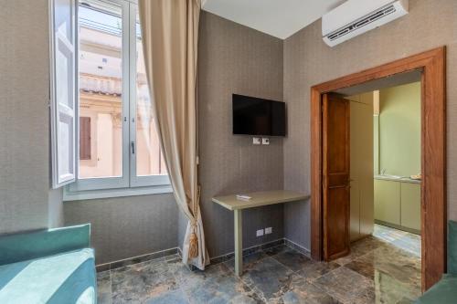 a room with a table and a tv and a window at Piazza di Spagna 51 Luxury guest house in Rome