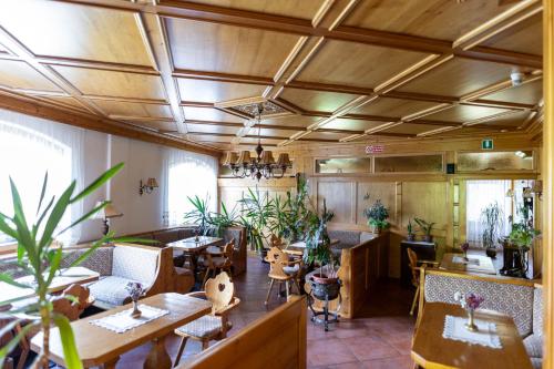 a restaurant with wooden ceilings and tables and chairs at Hotel il Cardo in San Vito di Cadore