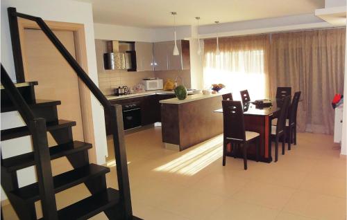 a kitchen and dining room with a table and a staircase at 7 Bedroom Cozy Home In Preveza in Kanali