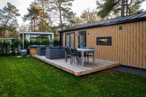 a backyard with a table and chairs and a house at Wellnesshuisje in de Sallandse Heuvelrug in Haarle