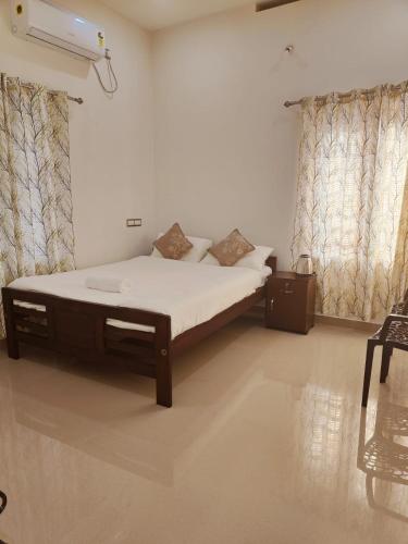 a large bed in a room with curtains at Palm Paradise Home Stay in Varkala