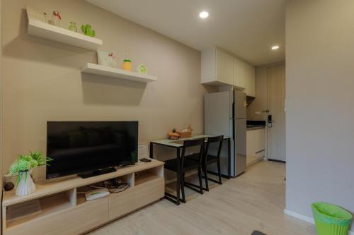 a living room with a flat screen tv and a table at Nimman Soi 5, Chiang Mai in Chiang Mai
