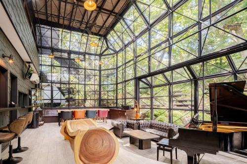una habitación con un gran edificio de cristal con un piano en クリエイティブな人の遊び場!最大16名リンカンスタジオRINKAN Studio, en Ito