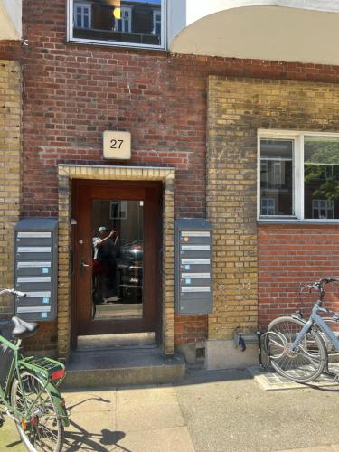 a brick building with a door with a man taking a picture at Spacious apartment in central Copenhagen in Copenhagen